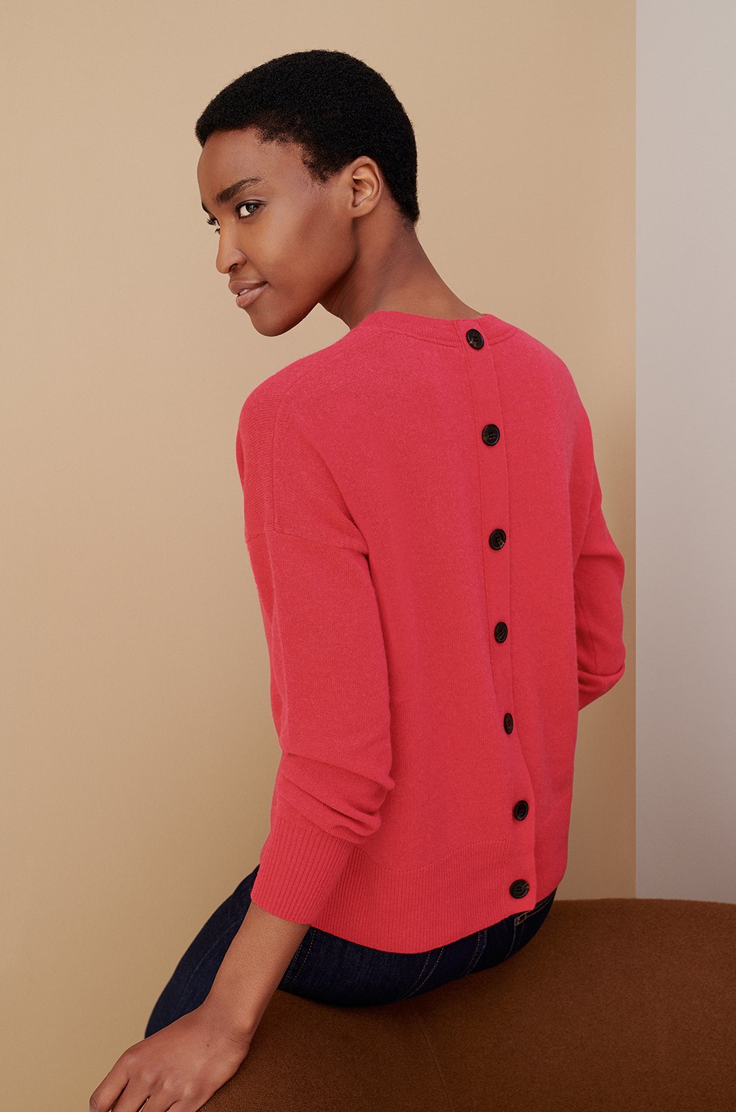 Model wears a bright jumper with button detailing from Hobbs.