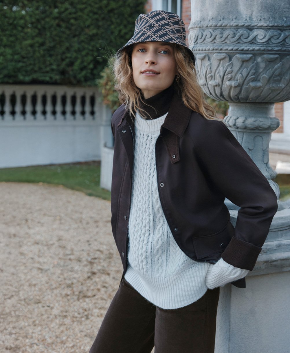 A woman wearing a Hobbs chocolate barn jacket.