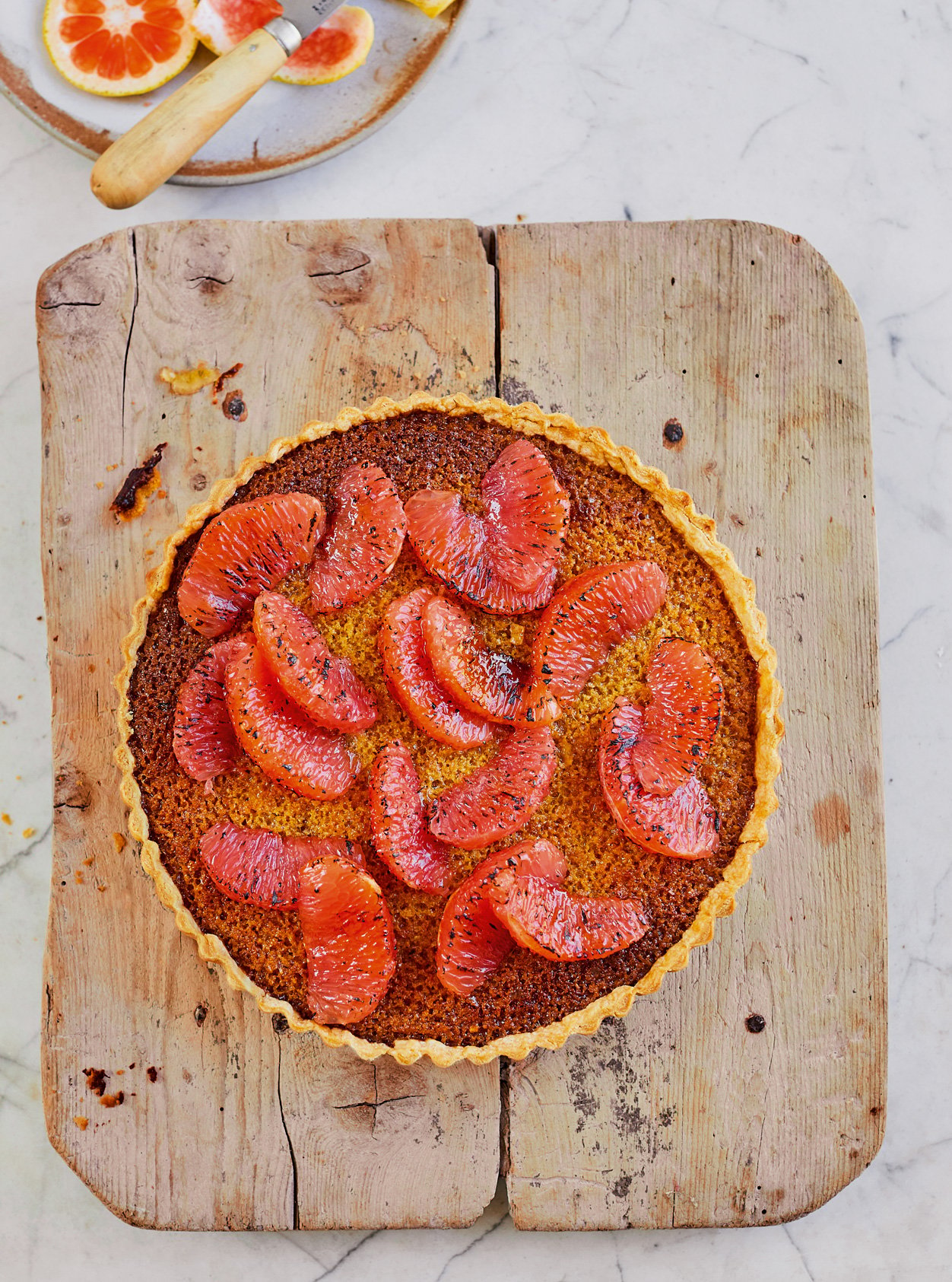 Prue Leith's Grapefruit Treacle Tart on a wooden board