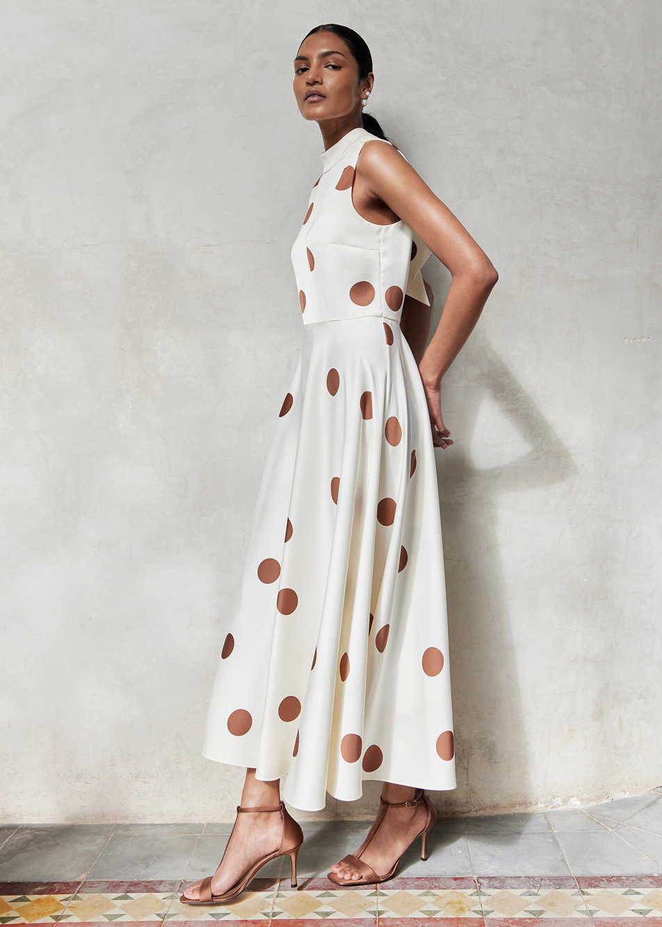 An image of a model wearing a polka dot ivory occasion dress.