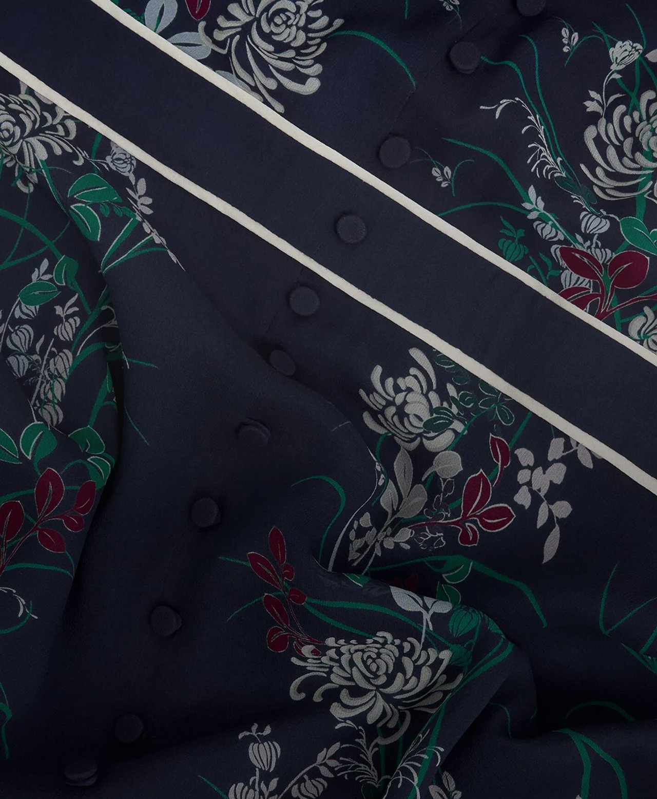 A woman wearing a navy, floral, Hobbs occasion dress.