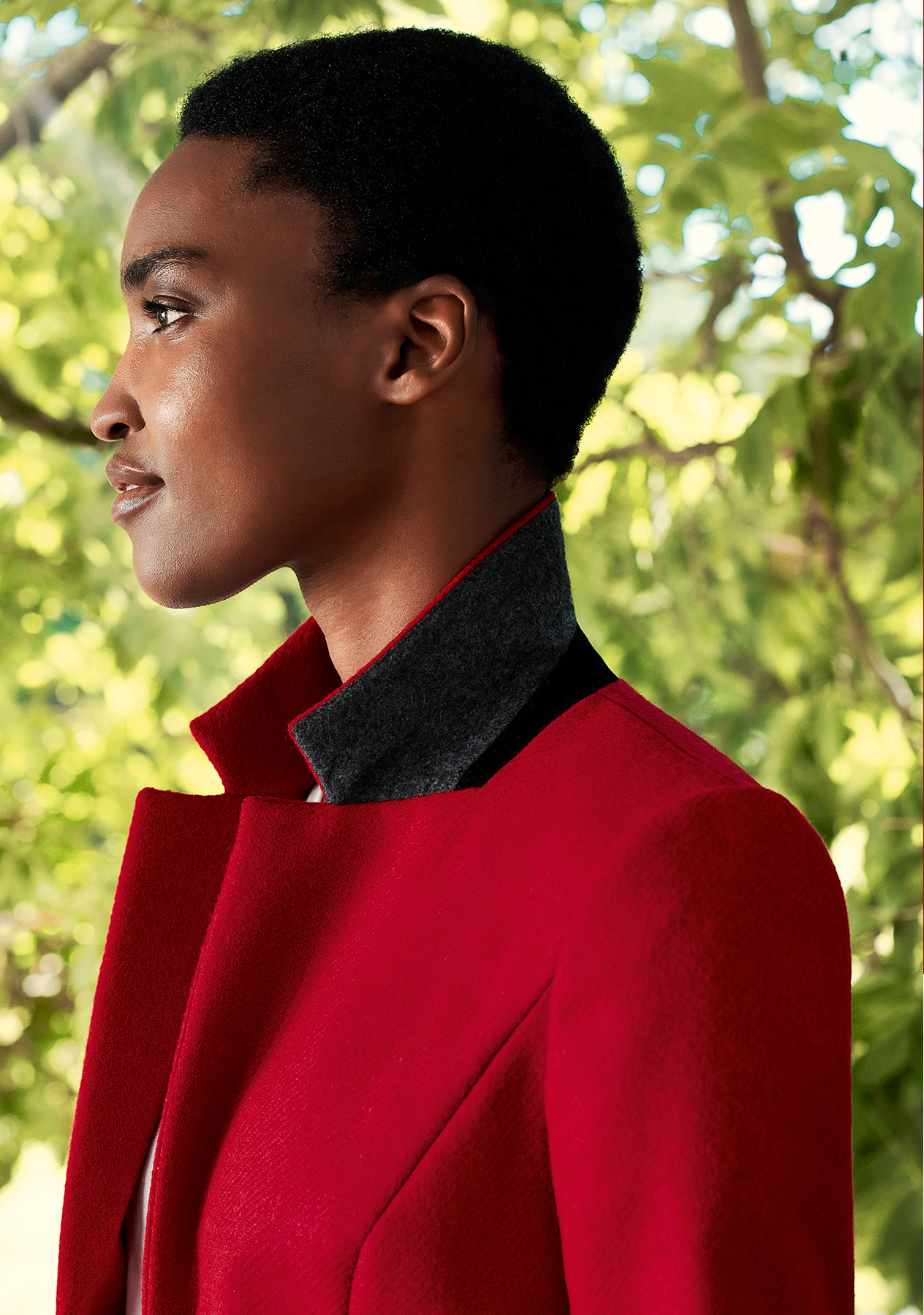 Close-up image of model wearing a Hobbs red jacket with the collar turned up.