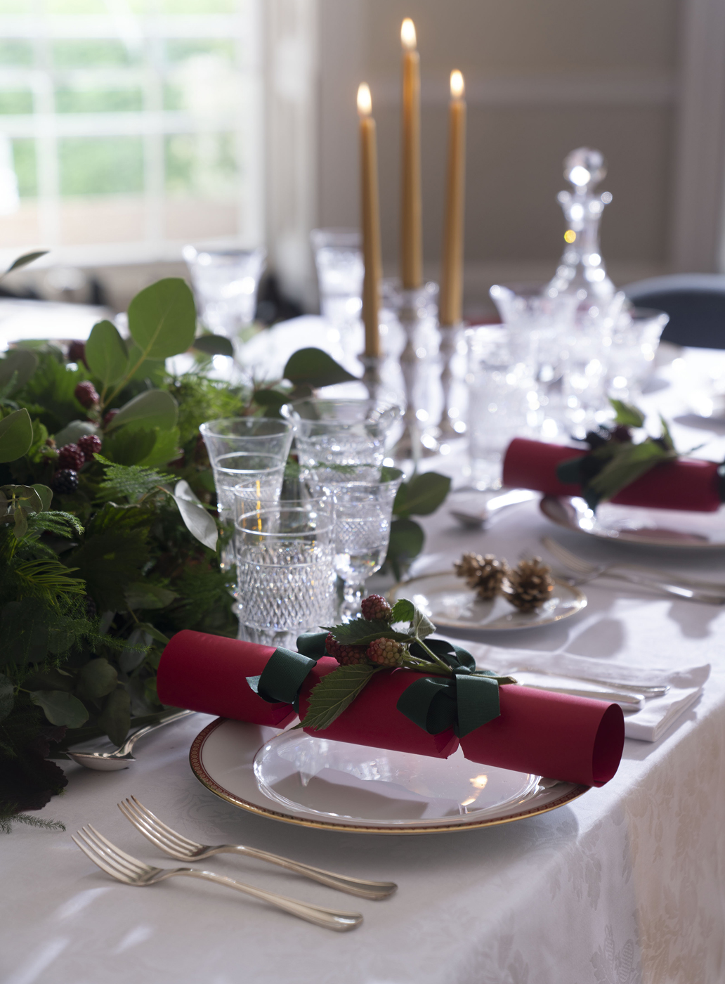 Close up on a red Christmas cracker displayed on a dining table.