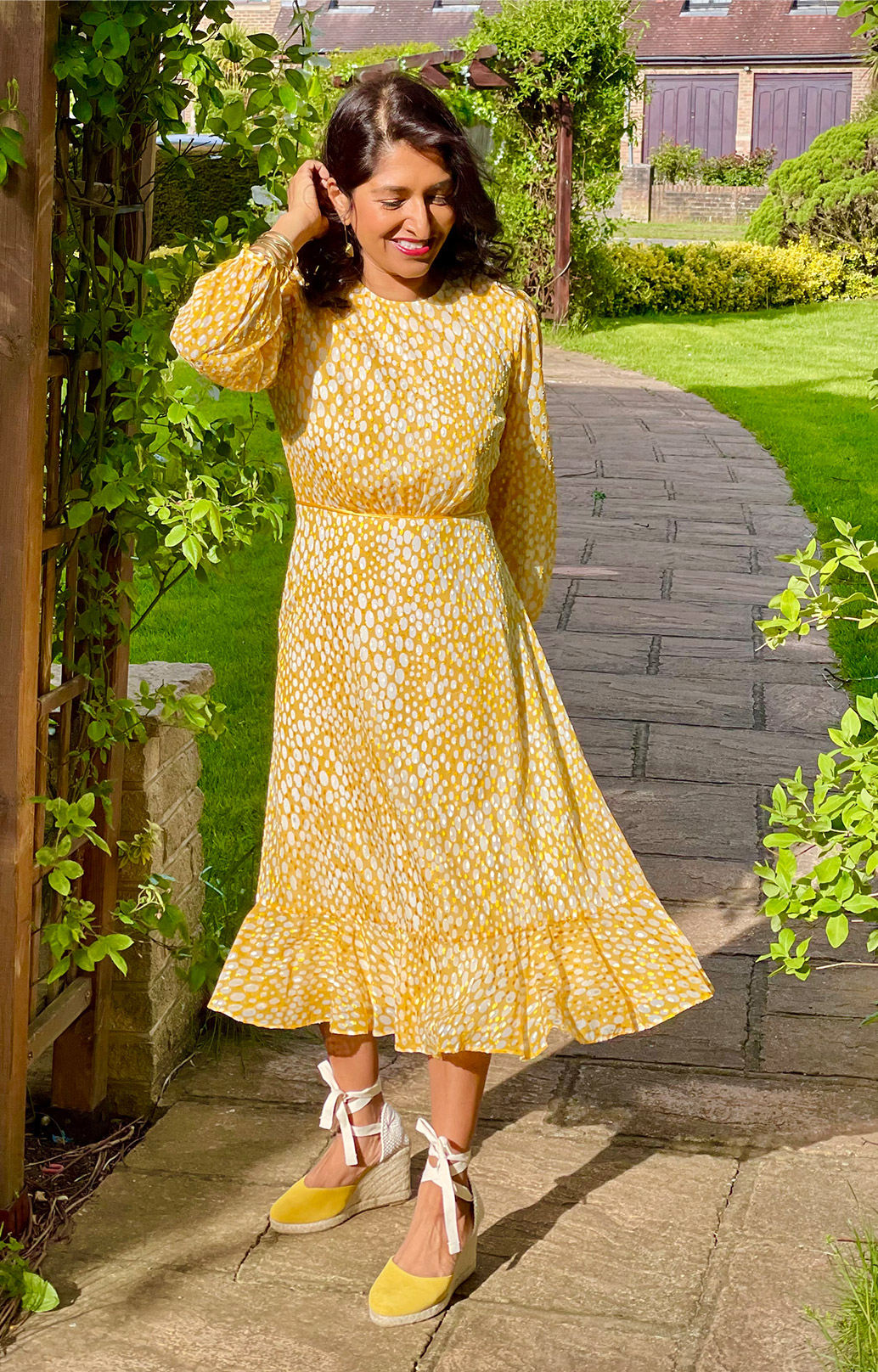 Fashion blogger @monikagoestowork photographed in her garden wearing Hobbs' Lexi yellow jacquard dress.