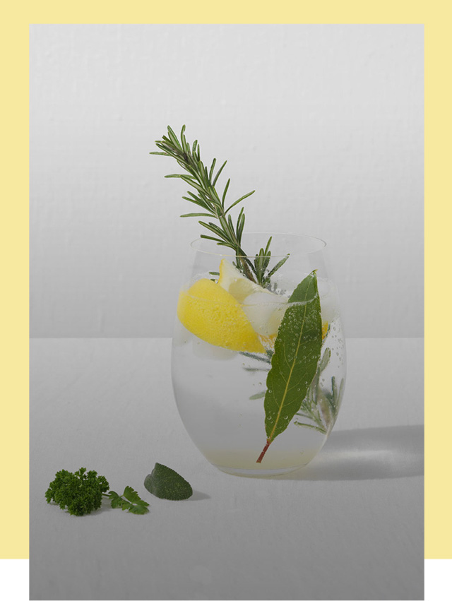 Glass containing refreshing Gin Fizz Cocktail with Lemon and Rosemary