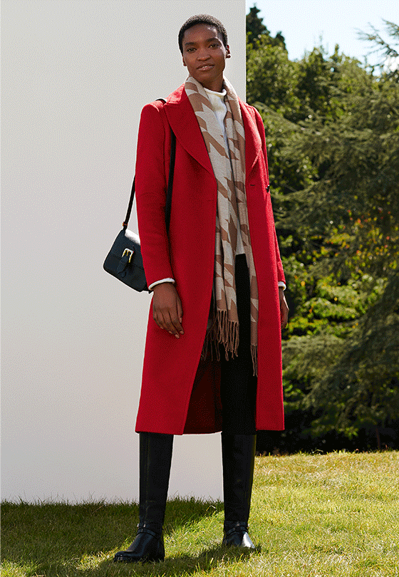 Full length image of model wearing a Hobbs red coat and houndstooth scarf.
