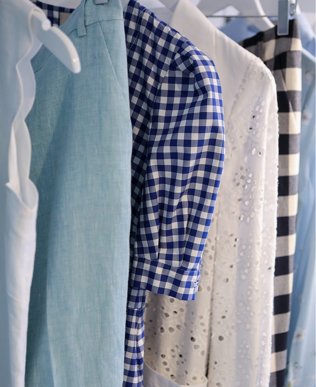 A rail of summer appropriate clothes in on tren gincham check and pale blue linen