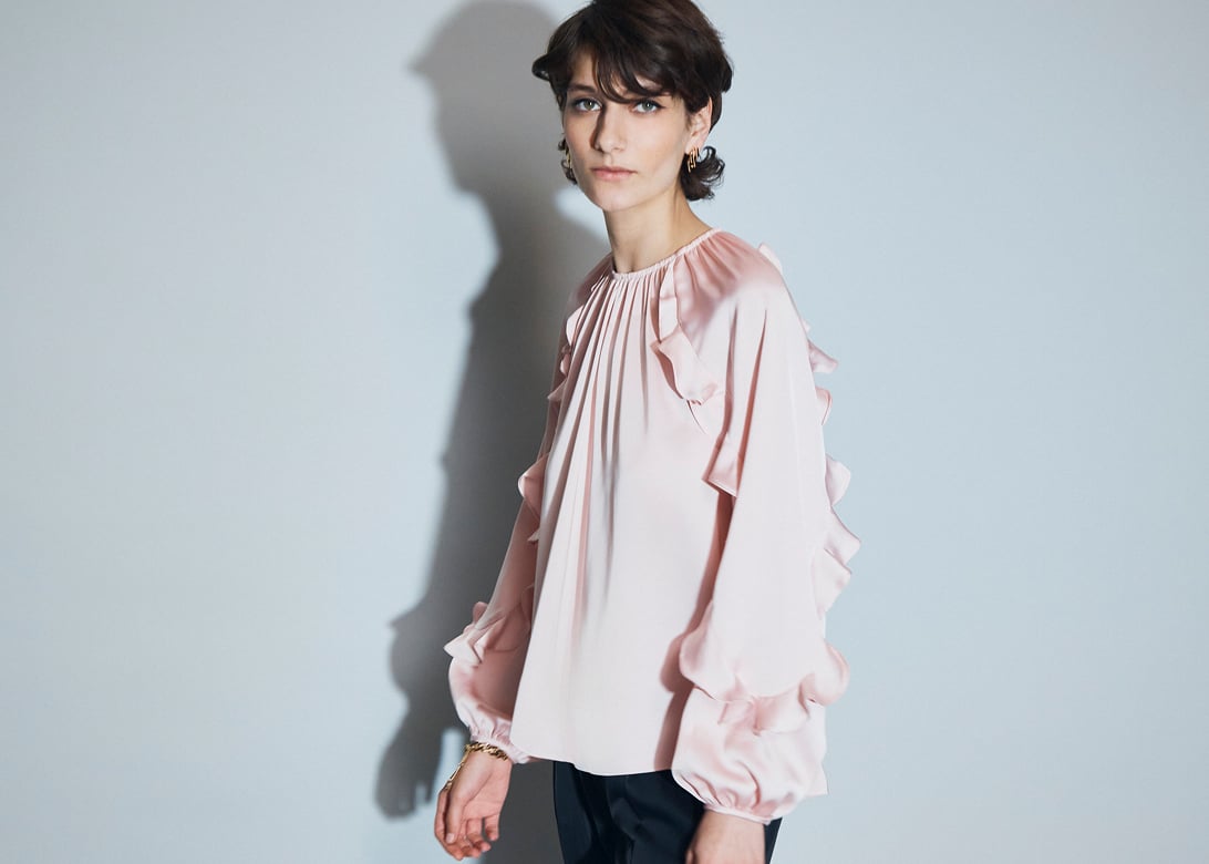 Model photographed in a pink blouse.