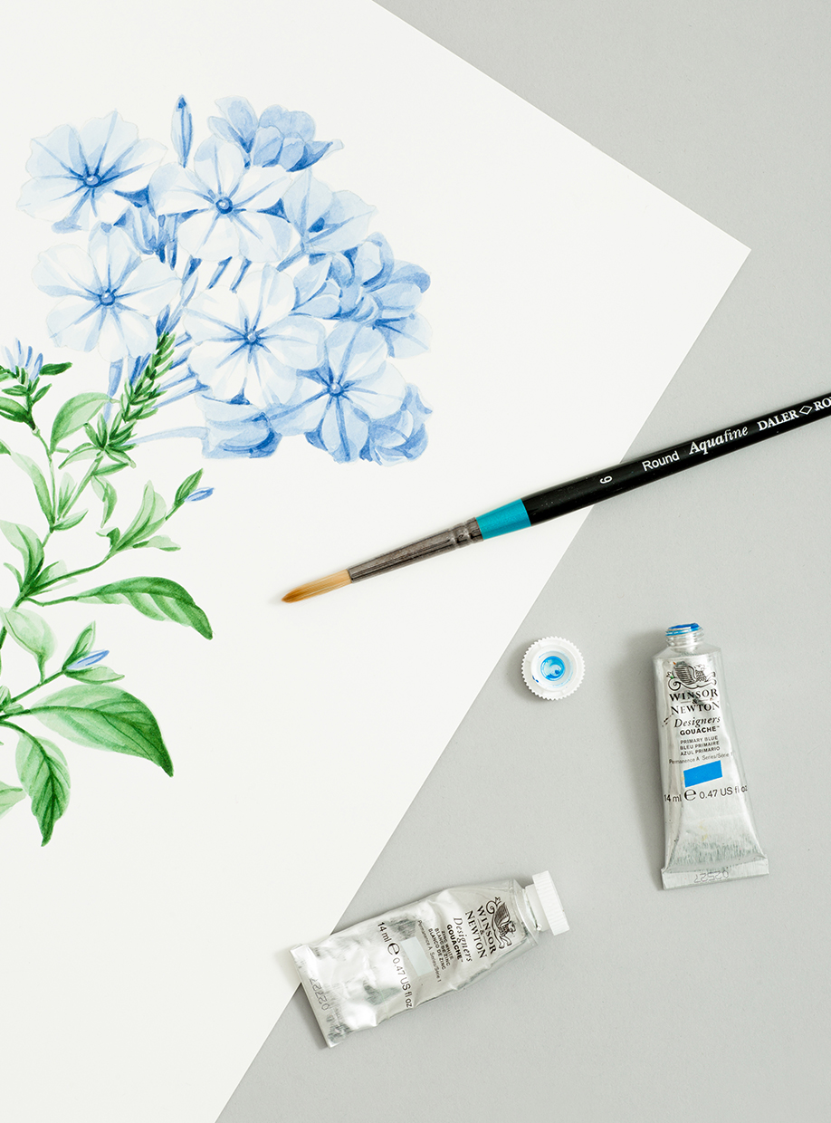 Still life image of a hand-painted floral design, paintbrush and paints.